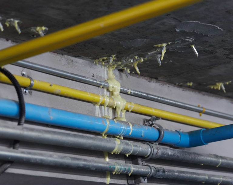 PU grout injection sealing a leak around ceiling pipes