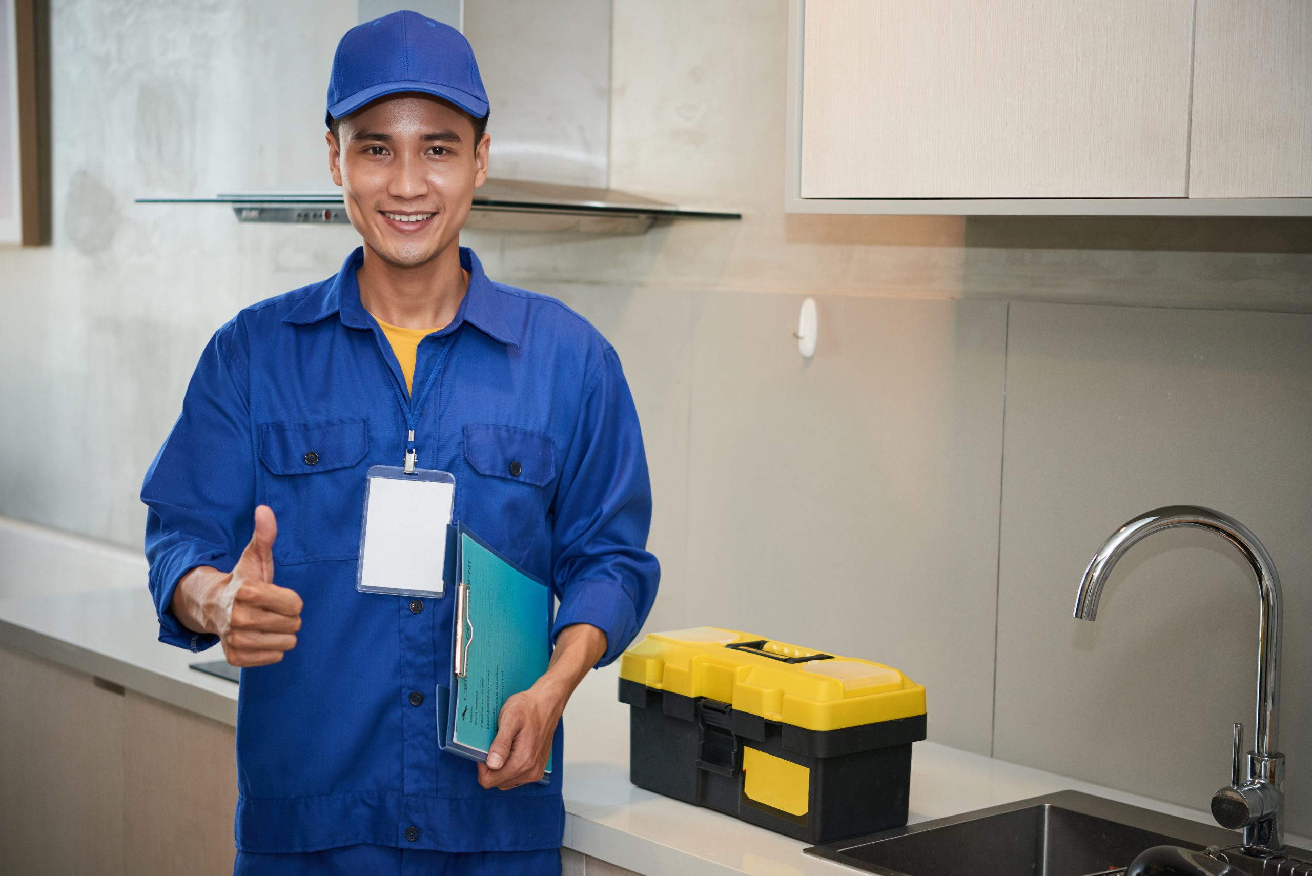 Portrait of happy young repairman in kitchen