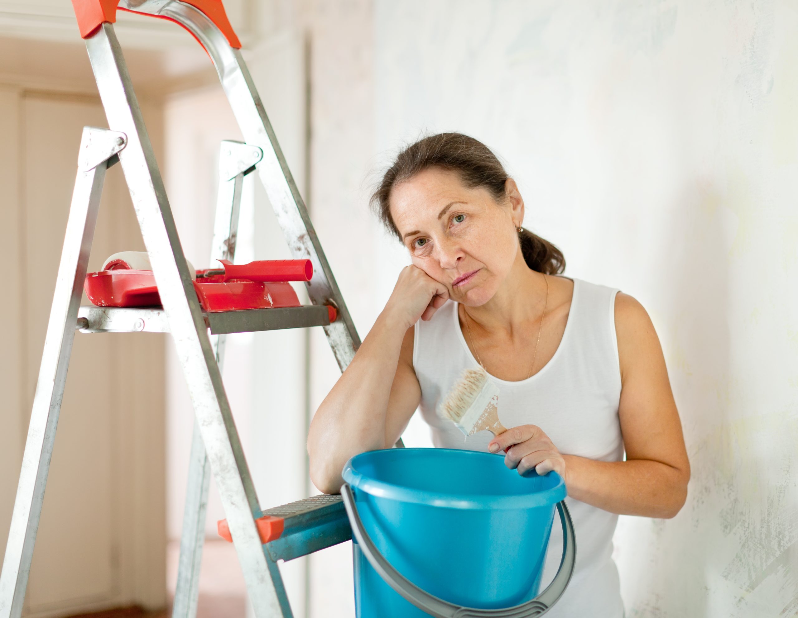 weariness mature woman makes repairs at home